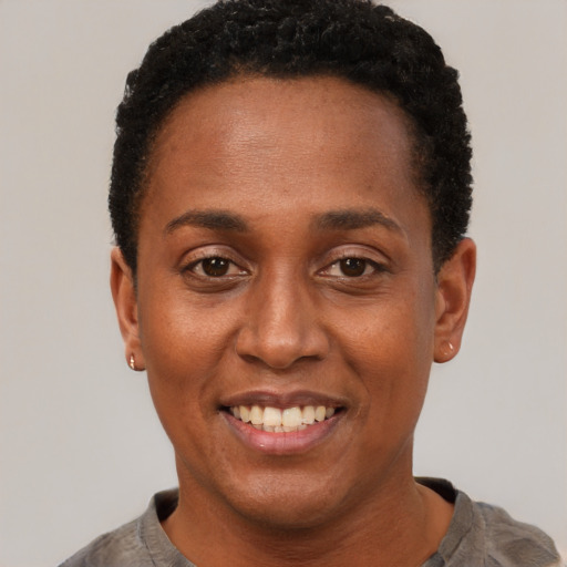 Joyful black adult female with short  black hair and brown eyes