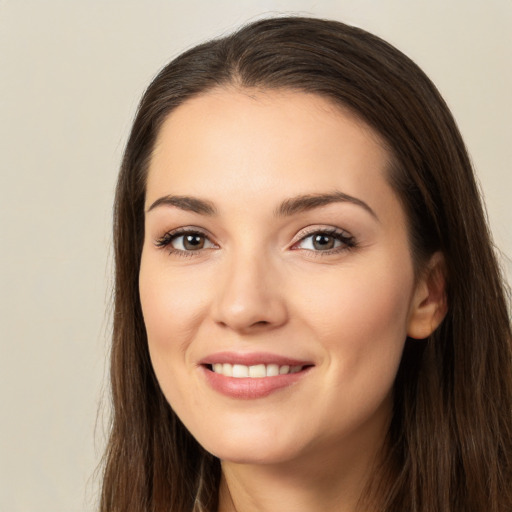 Joyful white young-adult female with long  brown hair and brown eyes