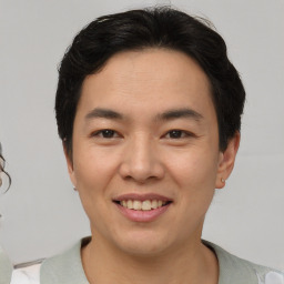 Joyful asian young-adult male with short  brown hair and brown eyes