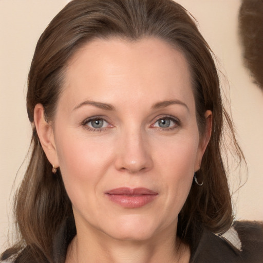 Joyful white adult female with medium  brown hair and grey eyes