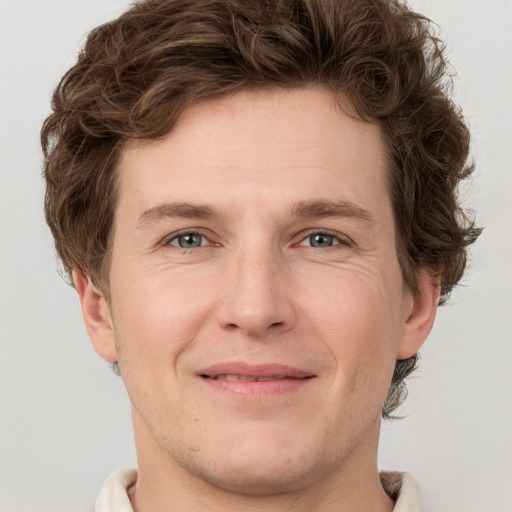 Joyful white adult male with short  brown hair and grey eyes