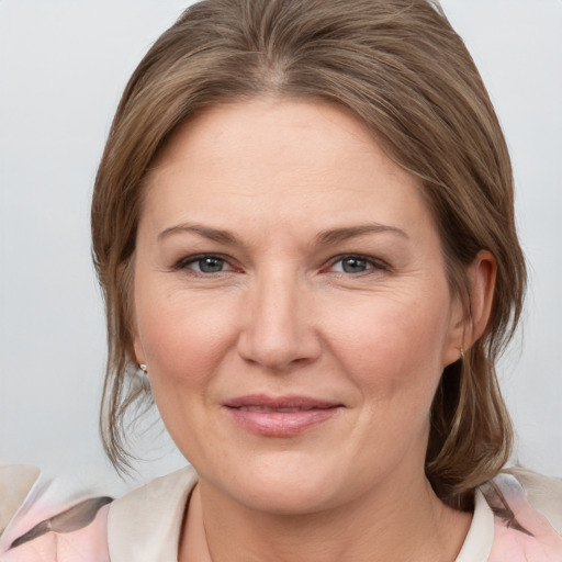 Joyful white adult female with medium  brown hair and grey eyes