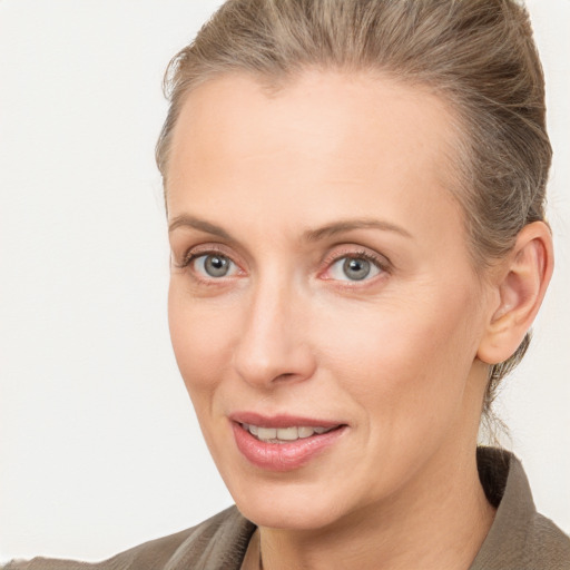 Joyful white adult female with medium  brown hair and grey eyes