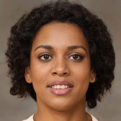Joyful black young-adult female with medium  brown hair and brown eyes