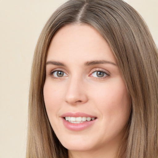 Joyful white young-adult female with long  brown hair and green eyes