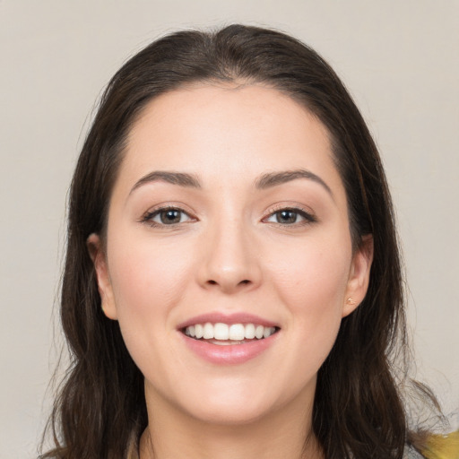 Joyful white young-adult female with long  brown hair and brown eyes