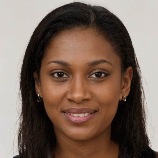 Joyful black young-adult female with long  brown hair and brown eyes