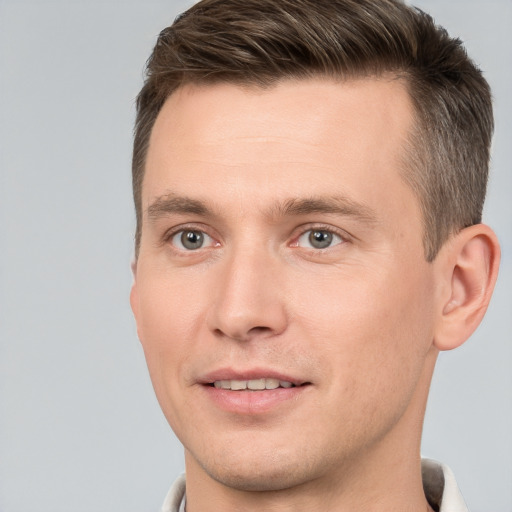 Joyful white young-adult male with short  brown hair and grey eyes