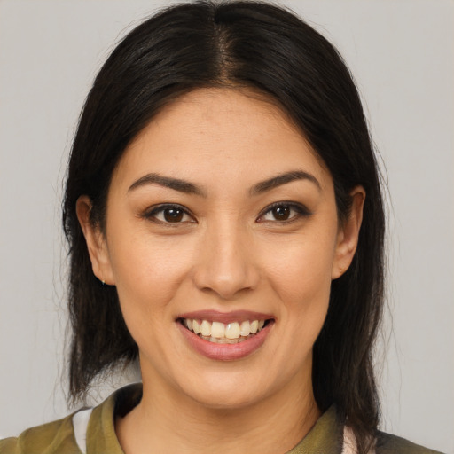 Joyful latino young-adult female with medium  brown hair and brown eyes