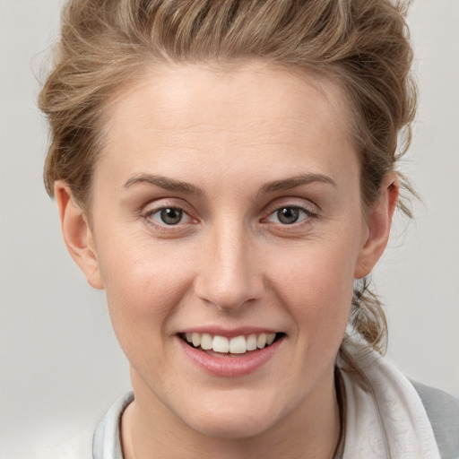 Joyful white young-adult female with medium  brown hair and grey eyes