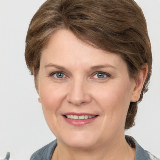 Joyful white adult female with medium  brown hair and grey eyes