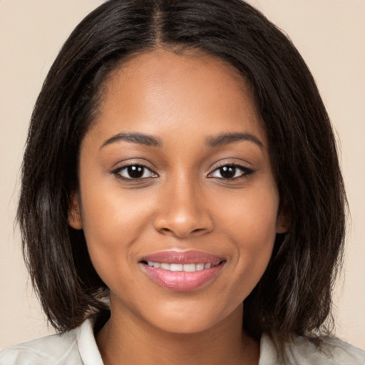 Joyful black young-adult female with medium  brown hair and brown eyes