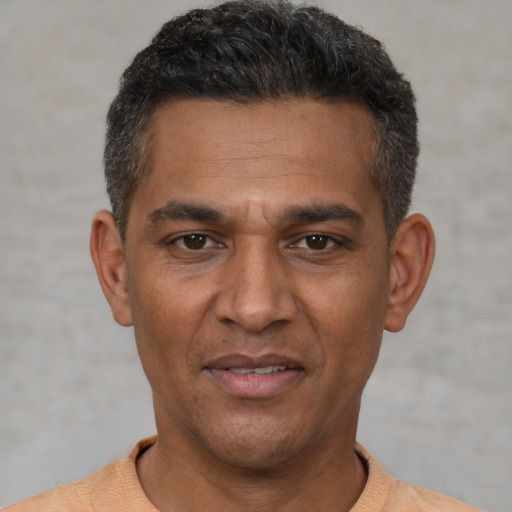 Joyful white adult male with short  black hair and brown eyes