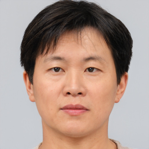 Joyful asian adult male with short  brown hair and brown eyes