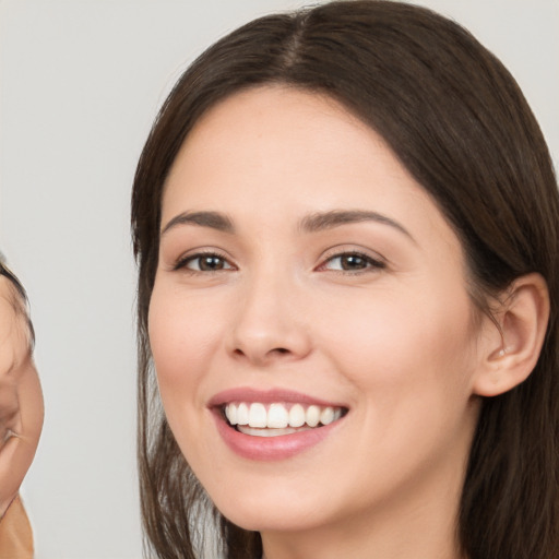 Joyful white young-adult female with long  brown hair and brown eyes