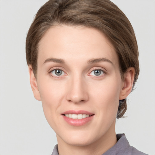 Joyful white young-adult female with short  brown hair and grey eyes