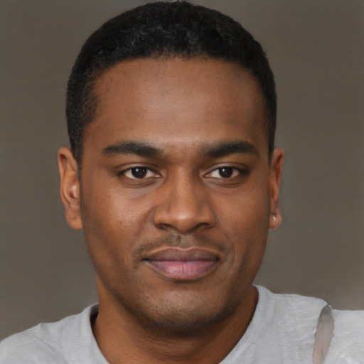 Joyful black young-adult male with short  brown hair and brown eyes