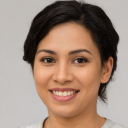 Joyful latino young-adult female with medium  brown hair and brown eyes