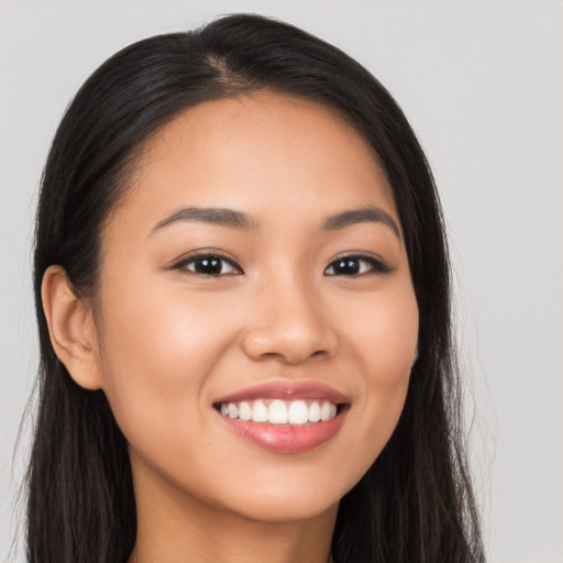 Joyful latino young-adult female with long  brown hair and brown eyes