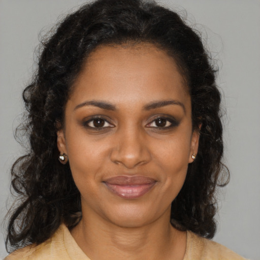 Joyful black young-adult female with long  brown hair and brown eyes