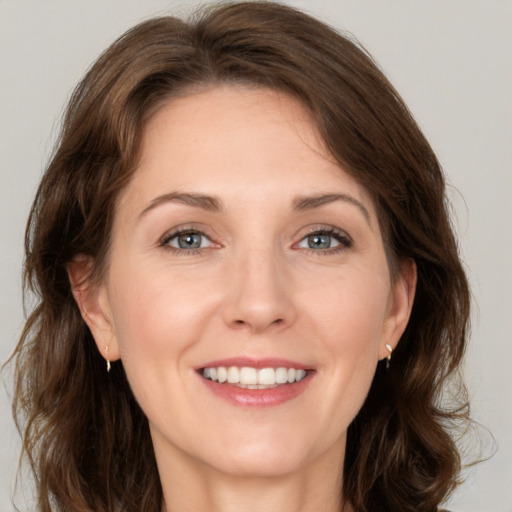 Joyful white adult female with medium  brown hair and grey eyes