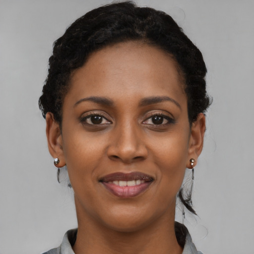 Joyful black young-adult female with short  black hair and brown eyes