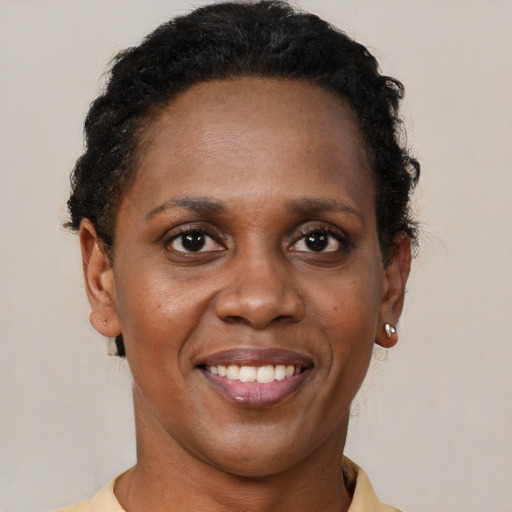 Joyful black adult female with short  brown hair and brown eyes