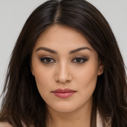 Joyful latino young-adult female with long  brown hair and brown eyes