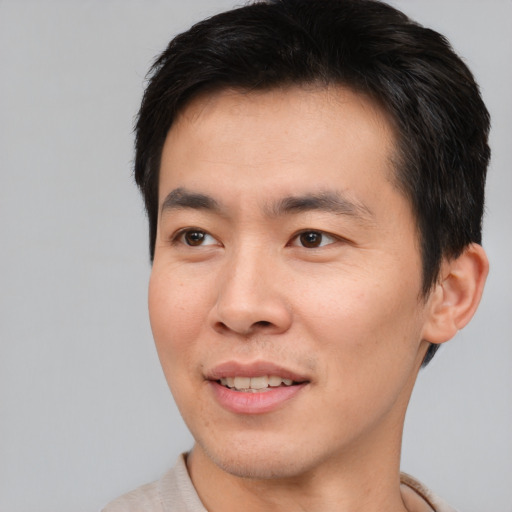 Joyful asian young-adult male with short  brown hair and brown eyes