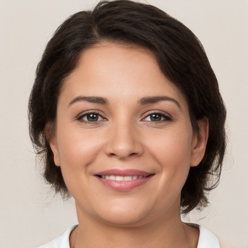 Joyful white young-adult female with medium  brown hair and brown eyes