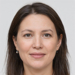 Joyful white adult female with long  brown hair and grey eyes