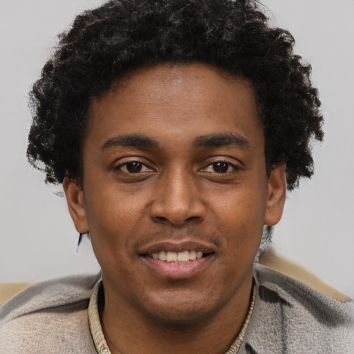 Joyful black young-adult male with short  black hair and brown eyes