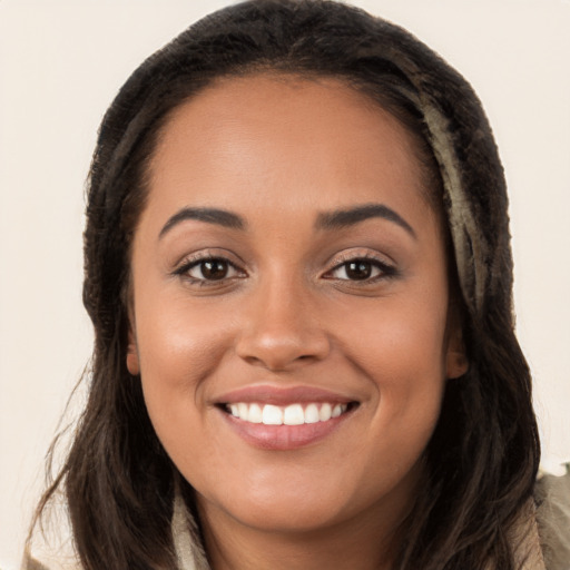 Joyful latino young-adult female with long  brown hair and brown eyes