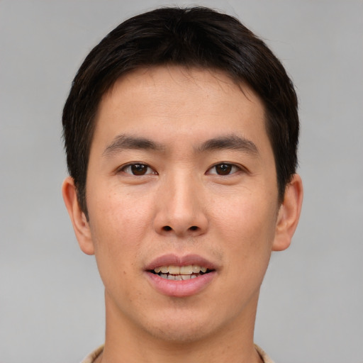 Joyful asian young-adult male with short  brown hair and brown eyes