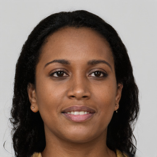 Joyful black young-adult female with long  brown hair and brown eyes