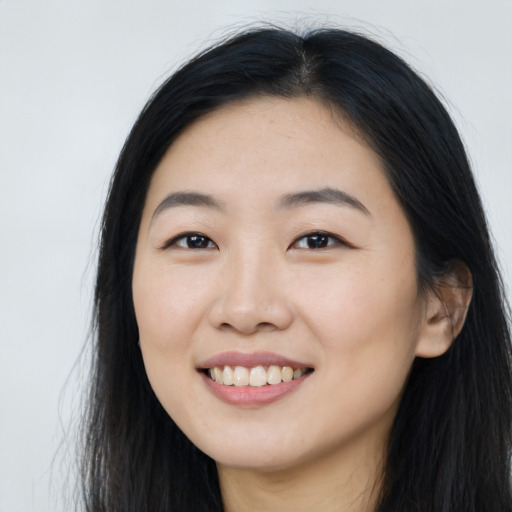 Joyful asian young-adult female with long  black hair and brown eyes