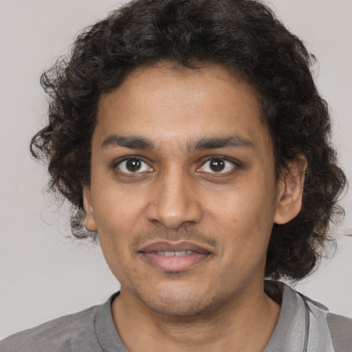 Joyful black young-adult male with short  brown hair and brown eyes