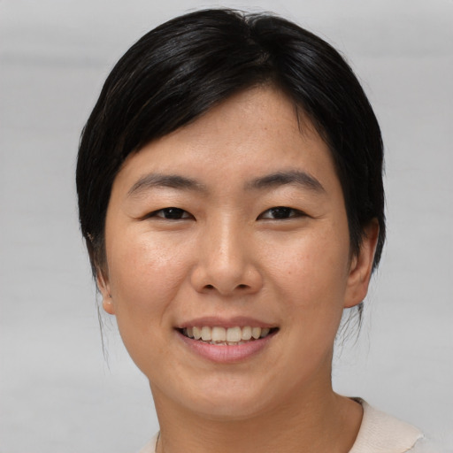 Joyful asian young-adult female with medium  black hair and brown eyes