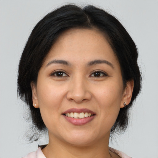 Joyful latino adult female with medium  brown hair and brown eyes