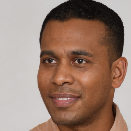 Joyful black young-adult male with short  black hair and brown eyes