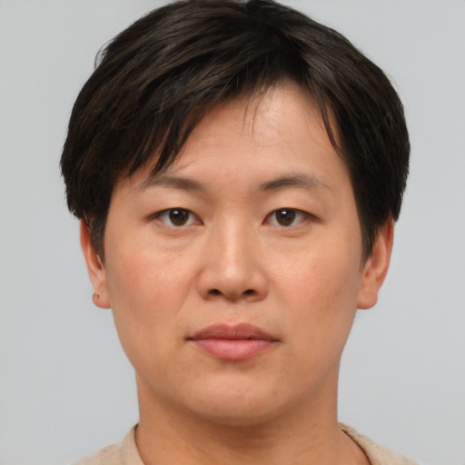 Joyful asian young-adult male with short  brown hair and brown eyes