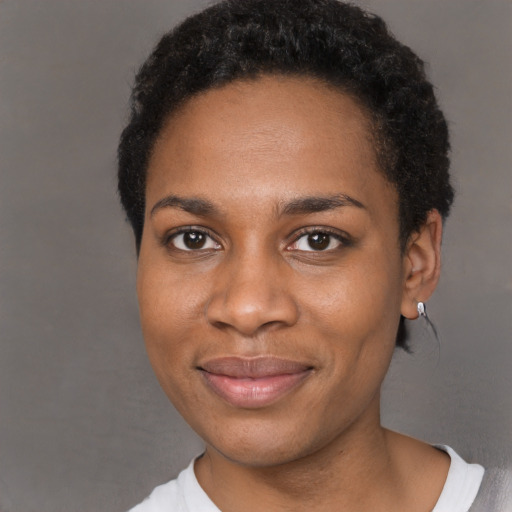 Joyful black young-adult female with short  black hair and brown eyes