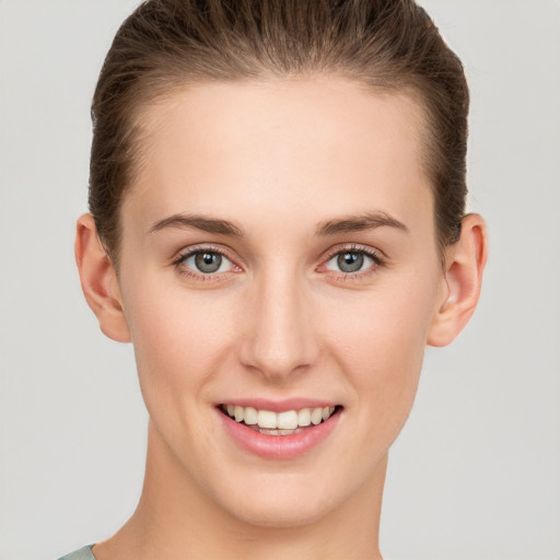 Joyful white young-adult female with short  brown hair and grey eyes