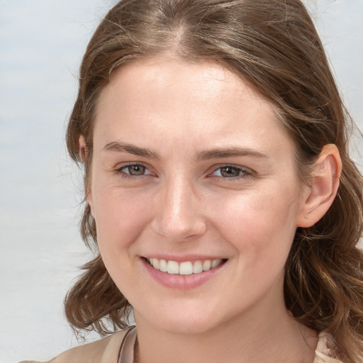 Joyful white young-adult female with medium  brown hair and blue eyes