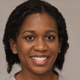 Joyful black young-adult female with medium  brown hair and brown eyes