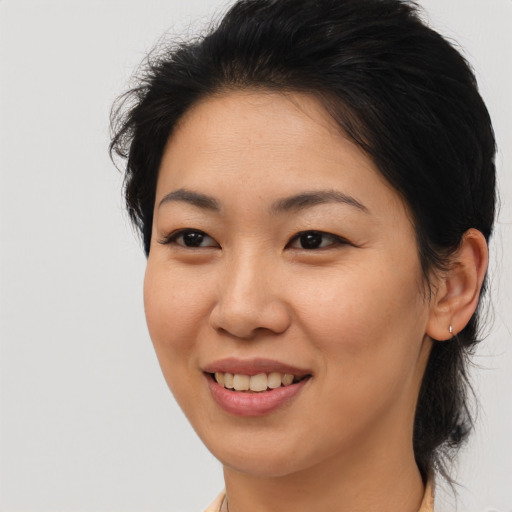 Joyful asian young-adult female with medium  brown hair and brown eyes