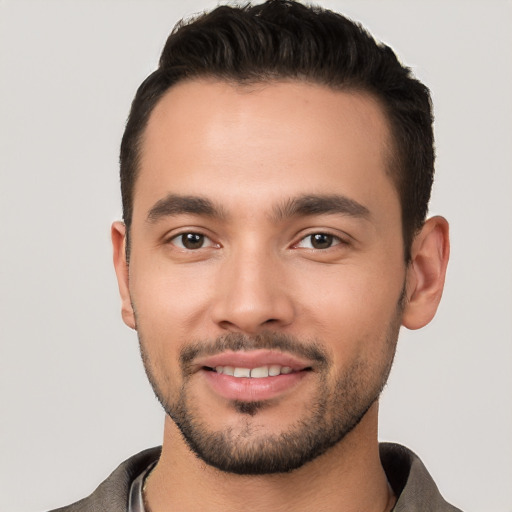 Joyful white young-adult male with short  black hair and brown eyes