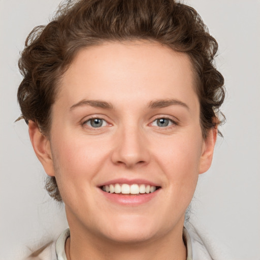 Joyful white young-adult female with short  brown hair and green eyes