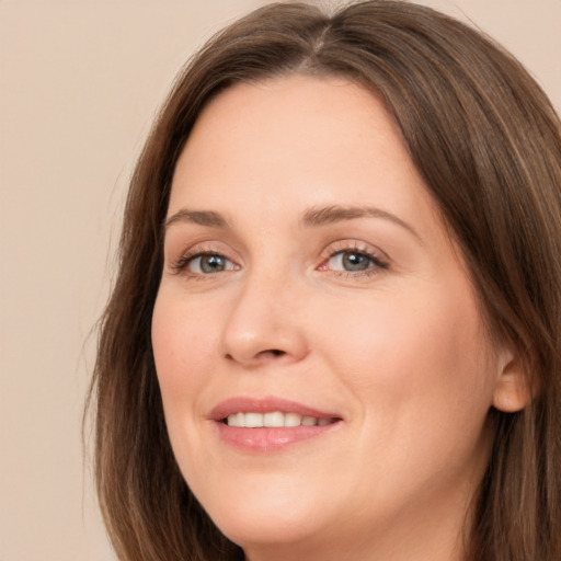 Joyful white adult female with long  brown hair and brown eyes