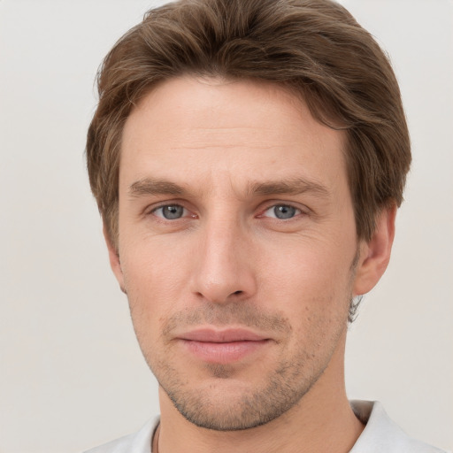 Joyful white young-adult male with short  brown hair and grey eyes